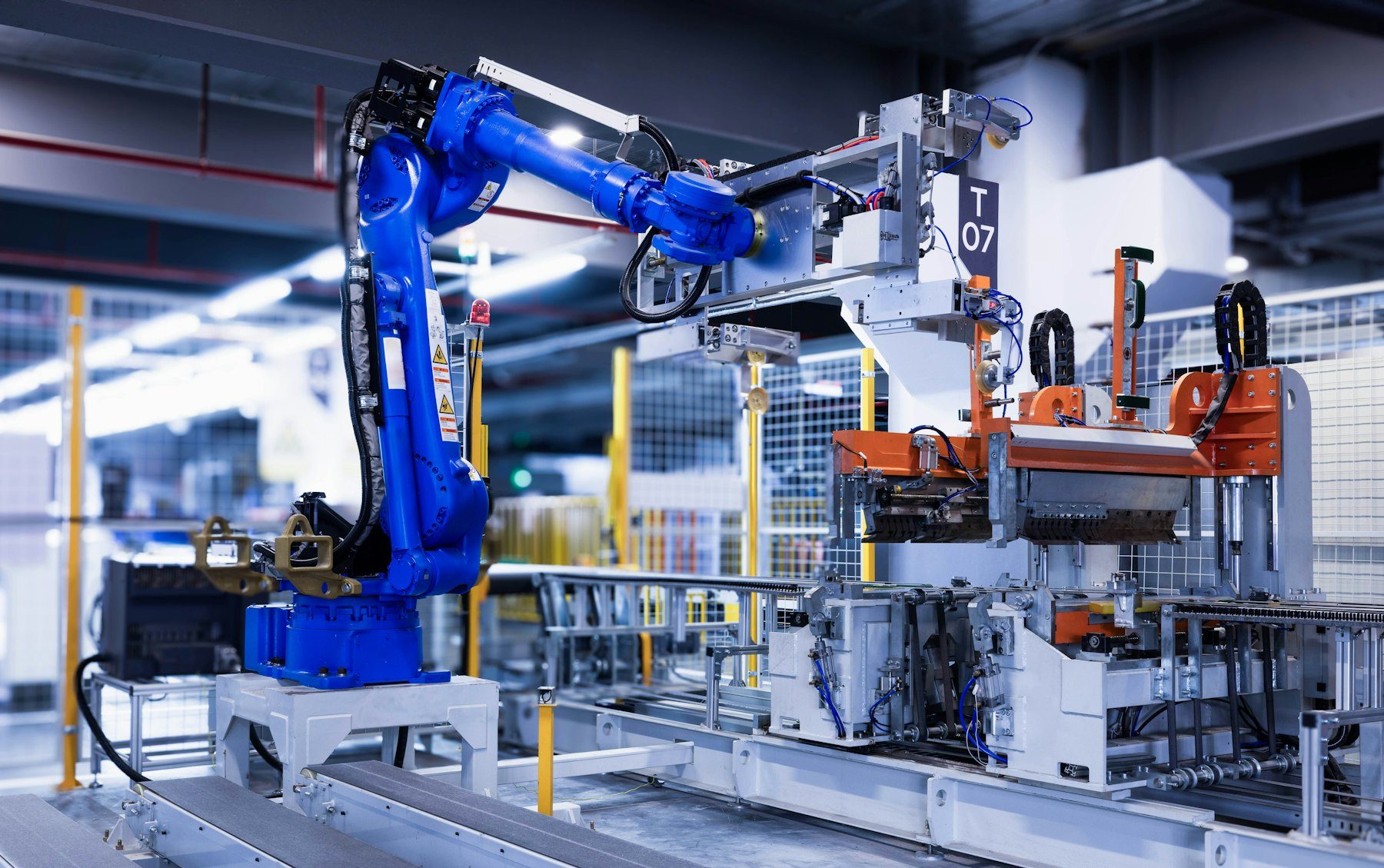 Blue industrial robot arm on a factory floor