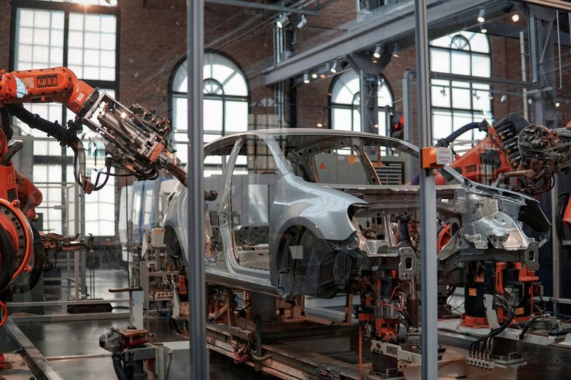 Robot arms working on a vehicle body inside an automotive plant