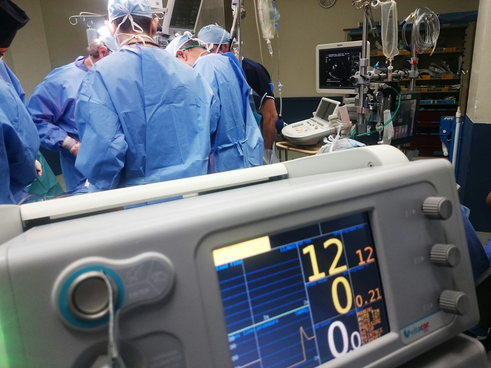 Patient monitor beside a surgical team in an operating room
