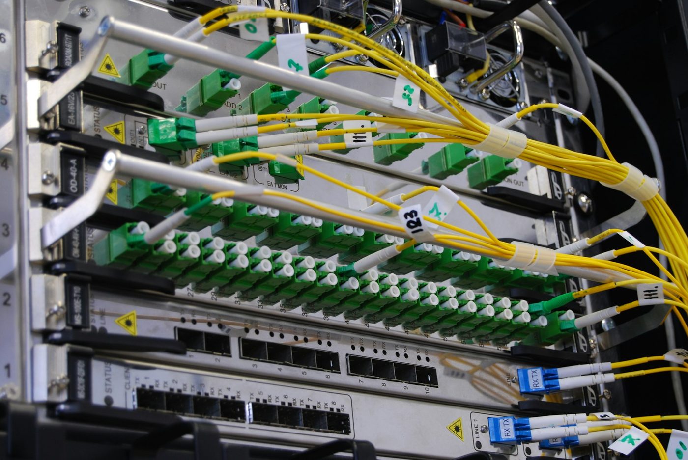Fibre optic cables patched into a network switch in a rack